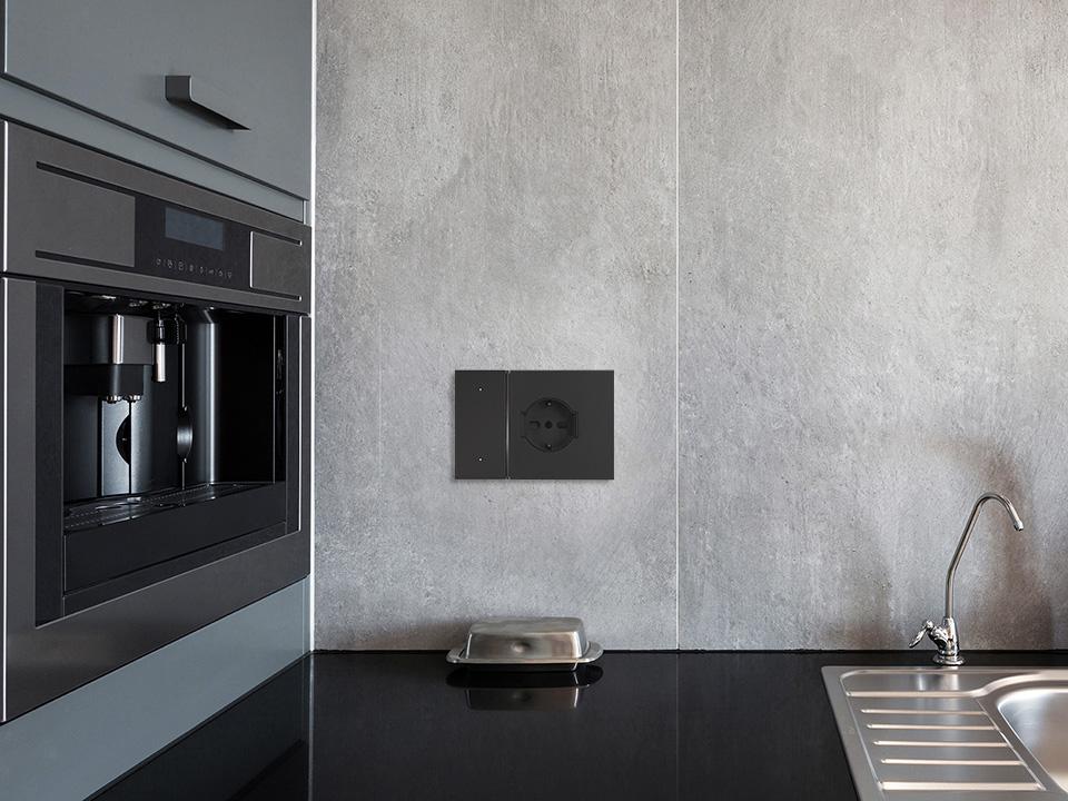 Angolo di una cucina con forno e comando digitale nero Living Now composto da comando luci e presa schuko