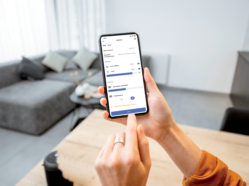 una persona comanda luci e tapparelle di casa dall'app Home+Control