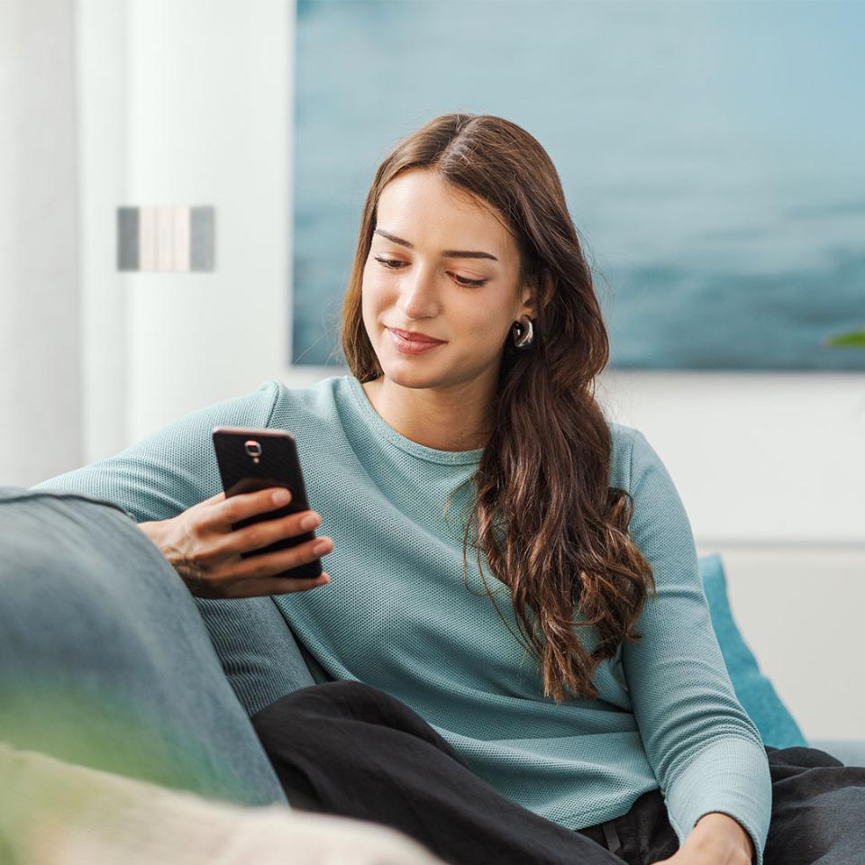 ragazza sorride guardando lo smartphone