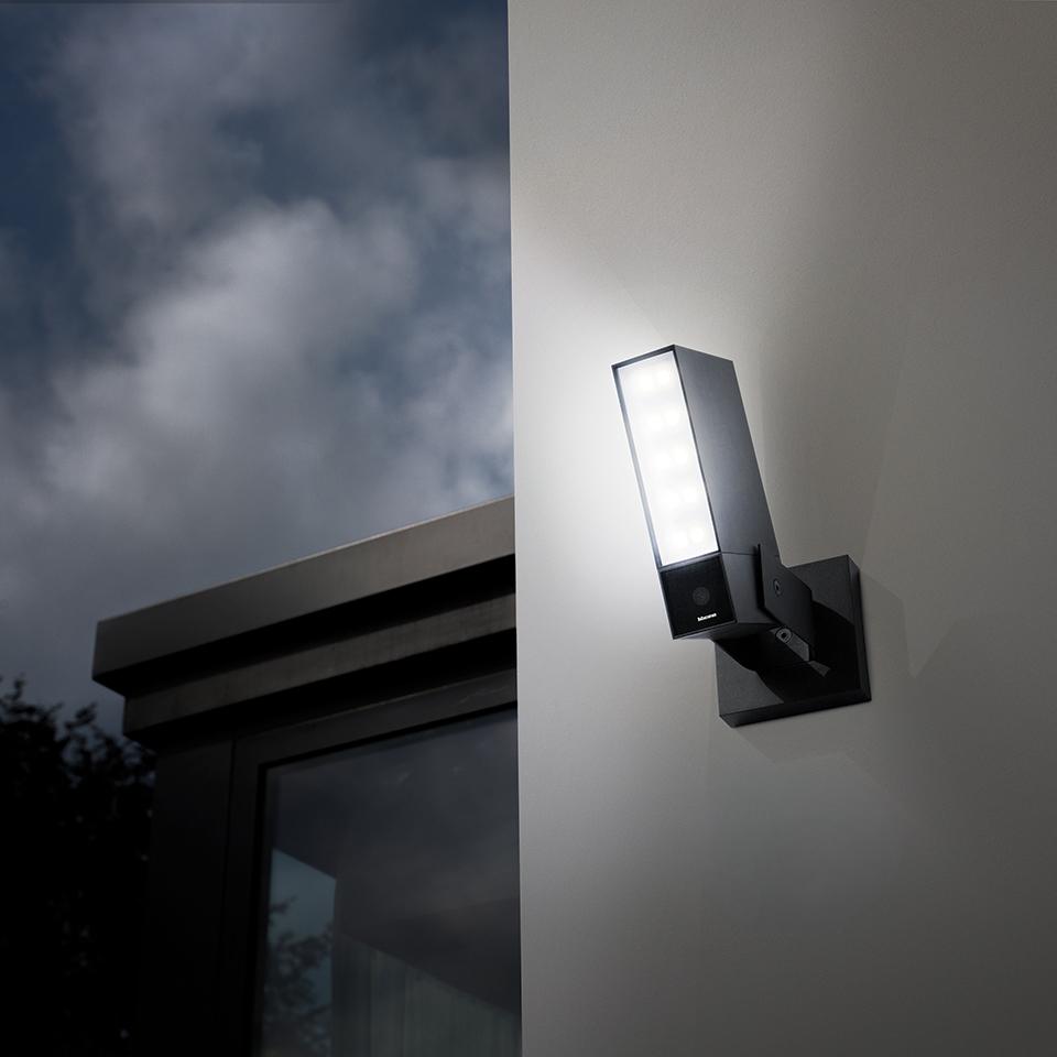 Vista notturna della telecamera Outdoor Original nera, installata sulla facciata di una casa